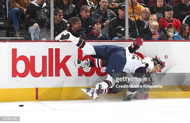 Alexei Kovalev of the Ottawa Senators is bodychecked off the puck by Anssi Salmela of the Atlanta Thrashers at Scotiabank Place on October 31, 2009...