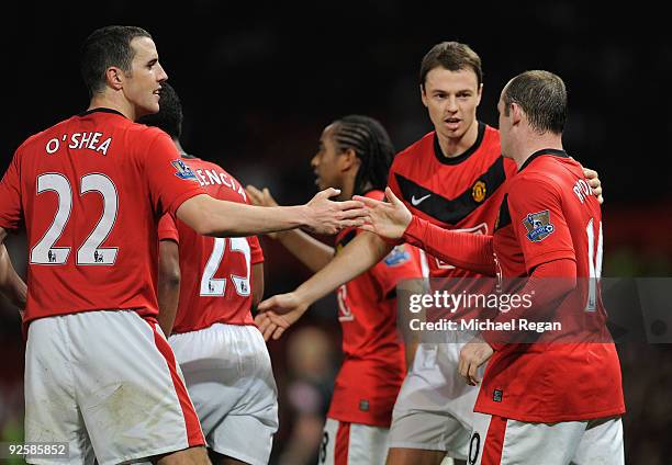 Wayne Rooney celebrates his goal with team mates John O'Shea and Jonny Evans during the Barclays Premier League match between Manchester United and...