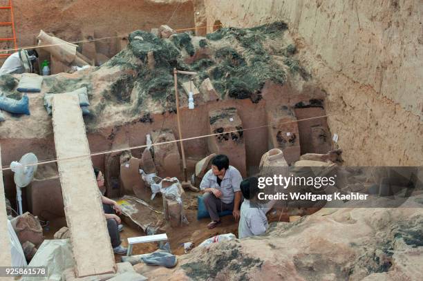 People are excavating warrior statues in the Terracotta Warriors and Horses Museum, displaying the collection of terracotta sculptures depicting the...