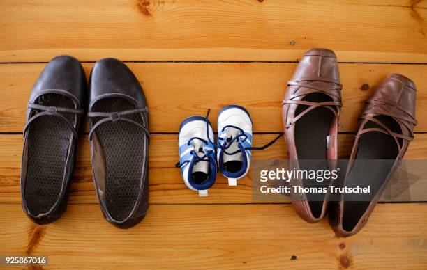 Berlin, Germany Symbolic photo on the topic: Children in same-sex marriages. A pair of children's shoes are between two pairs of women's shoes on...