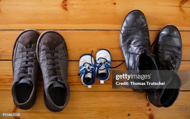 Berlin, Germany Symbolic photo on the topic: Children in same-sex marriages. A pair of children's shoes are between two pairs of men's shoes on March...