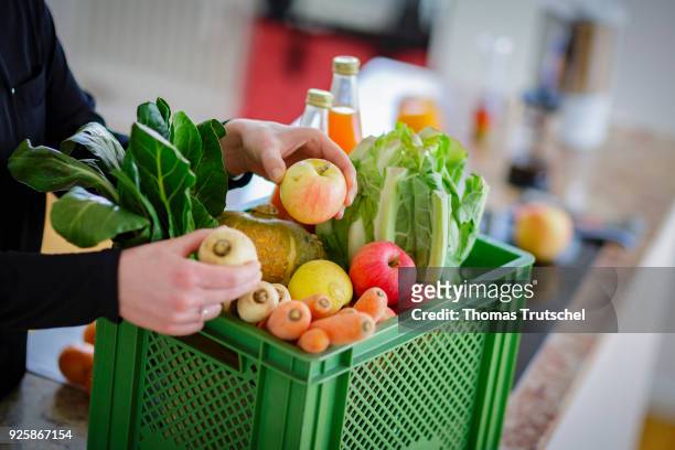 Berlin, Germany Posed Scene: A vegetable box scheme with fresh organic fruit and vegetables stands in a kitchen on March 01, 2018 in Berlin, Germany.