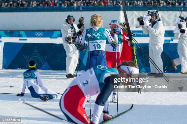 Ingvild Flugstad Oestberg of Norway finishes in fourth place as the winners celebrate during the Cross-Country Skiing - Ladies' 30km Mass Start...