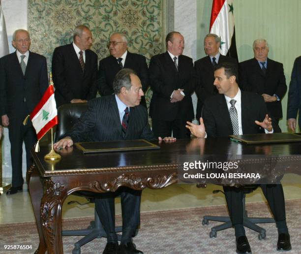 Syrian President Bashar al-Assad and his Lebanese counterpart Emile Lahoud talk before signing an agreement following the meeting of the...