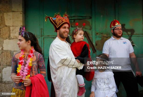 Israeli settlers celebrate the Jewish Purim holiday at al-Shuhada street in the divided West Bank town of Hebron, on March 01, 2018. The...