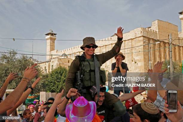 Israeli settlers celebrate the Jewish Purim holiday in front of Ibrahimi Mosque at al-Shuhada street in the divided West Bank town of Hebron, on...