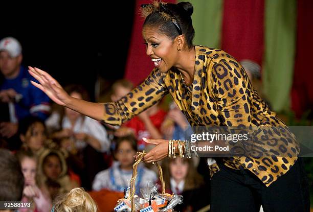 First lady Michelle Obama greets parents, trick-or-treaters and local school children at the north portico of the White House during a Halloween...