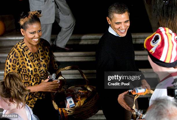 President Barack Obama and first lady Michelle Obama greet parents, trick-or-treaters and local school children at the north portico of the White...