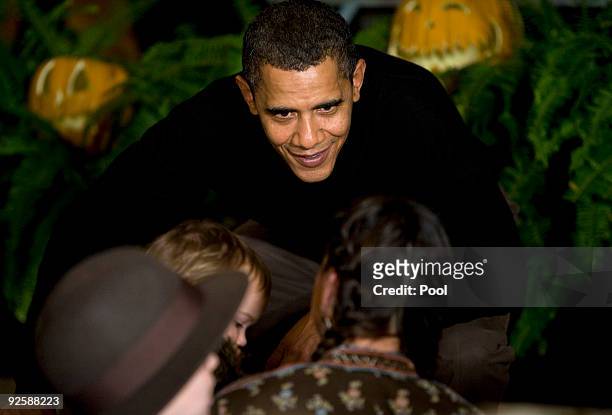President Barack Obama greets parents, trick-or-treaters and local school children at the north portico of the White House during a Halloween...