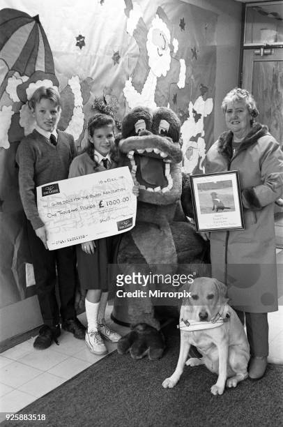 Wellhouse Middle School, Mirfield present a cheque to Guide Dogs for the Blind. Pictured are Richard and Nicola McBride presenting the cheque to...