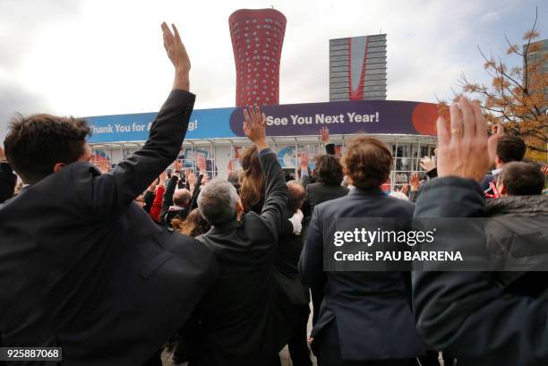 Group of attendees gather to pose for a photo outside the venue of the Mobile World Congress , on the last day of the world's biggest mobile fair, on...