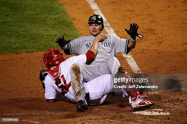 Nick Swisher of the New York Yankees collides with Carlos Ruiz of the Philadelphia Phillies as he scores in the top of the fifth inning in Game Three...