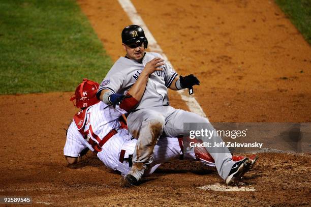 Nick Swisher of the New York Yankees collides with Carlos Ruiz of the Philadelphia Phillies as he scores in the top of the fifth inning in Game Three...