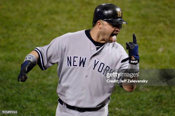 Nick Swisher of the New York Yankees celebrates after colliding with Carlos Ruiz of the Philadelphia Phillies and scoring in the top of the fifth...