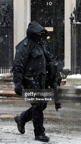 An armed policman patrols in the snow outside 10 Downing Street as Britain's Prime Minister Theresa May welcomes European Council President Donald...