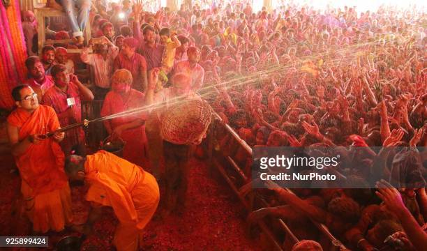 Priest water gun on devotees on the occasion of Holi festival celebration at historical Govind Dev Ji temple , in Jaipur, Rajasthan, India on 01...