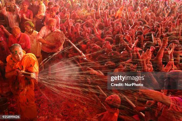 Priest water gun on devotees on the occasion of Holi festival celebration at historical Govind Dev Ji temple , in Jaipur, Rajasthan, India on 01...