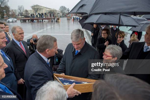 Senator Richard Burr gives a American flag, that flew at half mast during his memorial to Franklin Graham as the casket of American evangelist Billy...