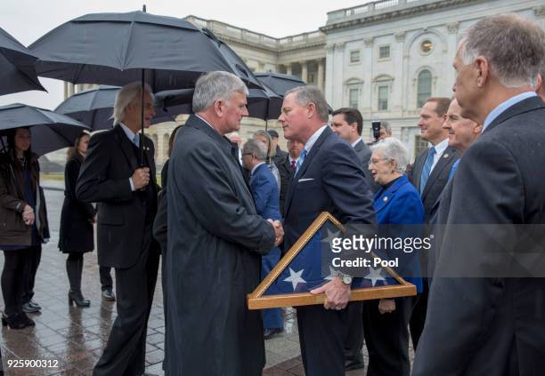 Senator Richard Burr gives a American flag, that flew at half mast during his memorial to Franklin Graham as the casket of American evangelist Billy...