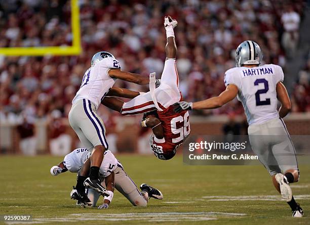 Wide receiver Ryan Broyles of the Oklahoma Sooners gets upended by defenders Darious Thomas and Troy Butler of the Kansas State Wildcats in the first...