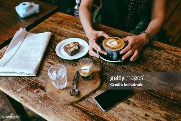 caffè e torta sul tavolo in un caffè nel centro di londra - coffee and news paper foto e immagini stock