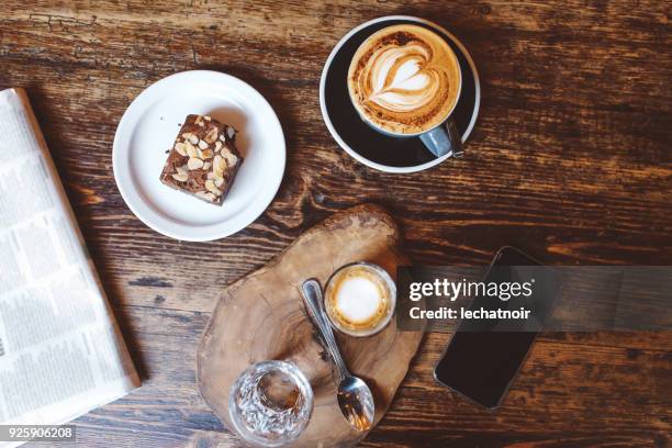 high angle view of coffee and cake on the table in a cafe in london downtown - evening news 2017 stock pictures, royalty-free photos & images