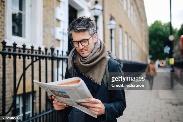 vintage portrait of a man reading newspapers in london downtown - printed media stock pictures, royalty-free photos & images