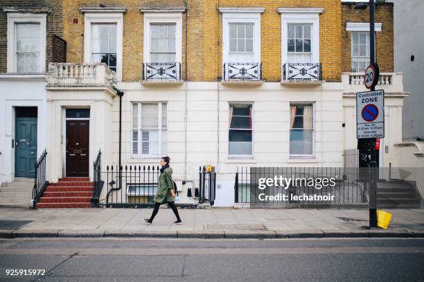 Young tourist woman walking on the streets of London holding her vintage film camera