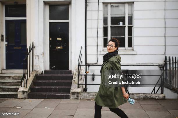 young tourist woman walking on the streets of london holding her vintage film camera - parka stock pictures, royalty-free photos & images
