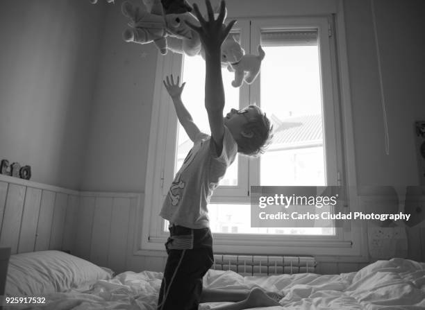 little boy playing with teddy bears in his bedroom - personas ciudad stock pictures, royalty-free photos & images