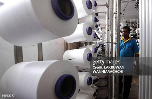 Sri Lankan worker stands next to thread spools at a garment factory in Colombo suburb Maharagama on October 20, 2009. Sri Lanka has agreed to study a...
