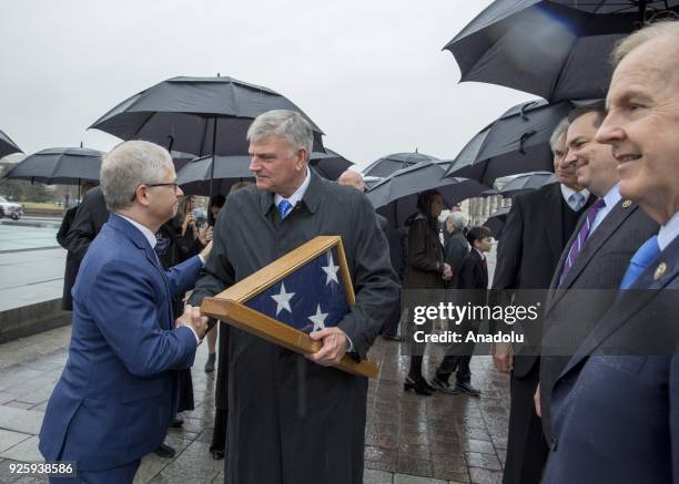 Rep. Patrick T. McHenry shakes hands with Franklin Graham as he holds an American flag while the casket of American evangelist Billy Graham exits the...