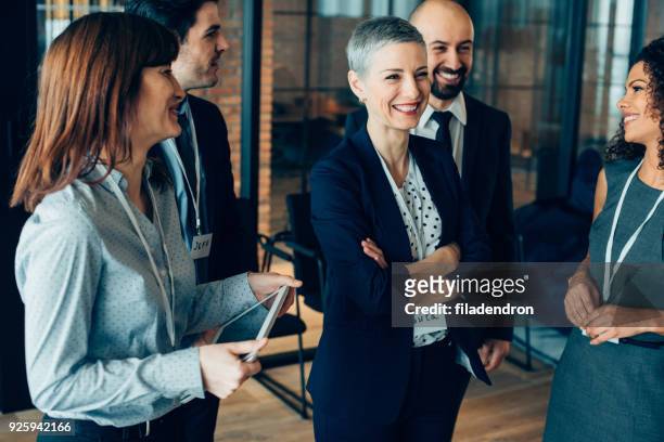laughing multiethnic team - casual work men and women laughing stock pictures, royalty-free photos & images