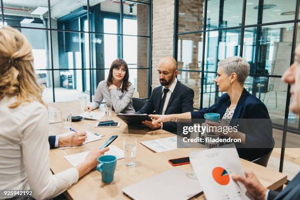 business team having meeting in an office - office serious stock pictures, royalty-free photos & images