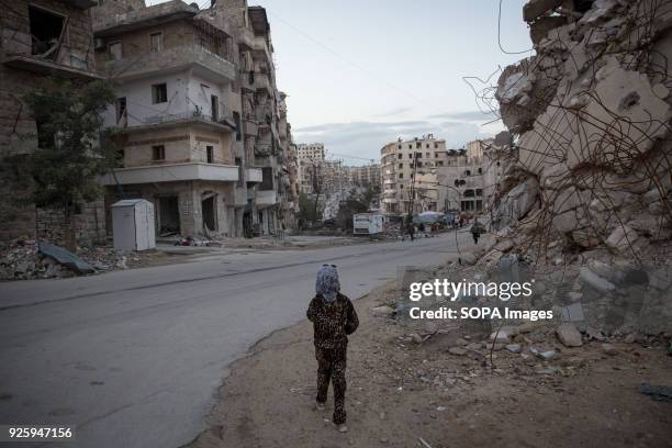 Young girl walks through her decimated neighbourhood in Ansari al Sharki, Aleppo. Aleppo used to be the largest city in Syria with population over...