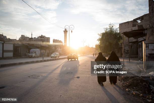 Women walk at sunset in east Aleppo. Aleppo used to be the largest city in Syria with population over 4.5 million before the war broke out in 2012....