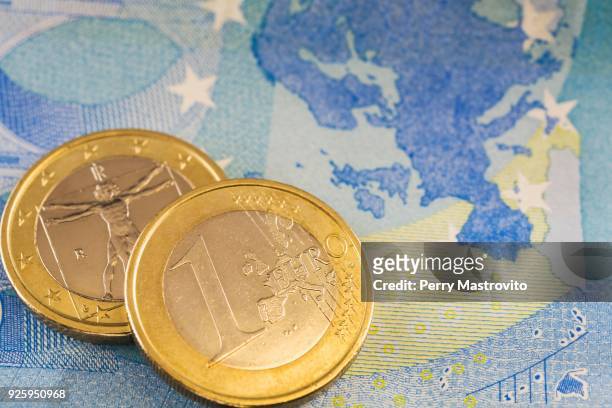 one euro coins on top of twenty euros paper currency bank note - twenty euro note stock-fotos und bilder