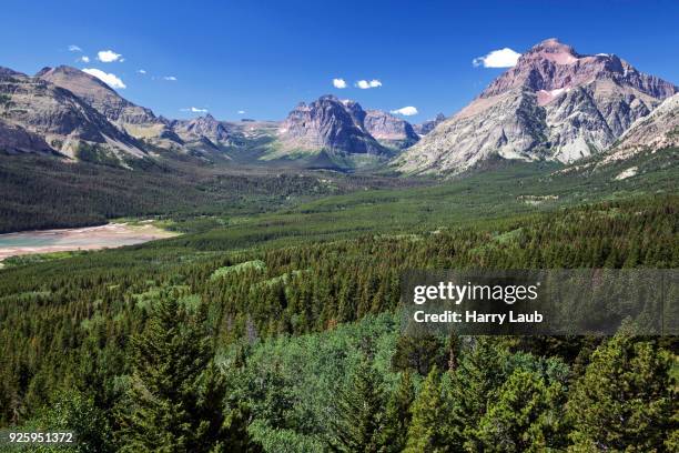 view on appistoki peak left, rising wolf mountain in the middle, spot mountain right, two medicine lake, glacier national park, montana, usa - lago two medicine montana - fotografias e filmes do acervo