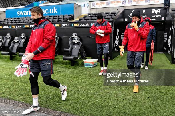 Lukasz Fabianski, Erwin Mulder and Kristoffer Nordfeldt enter the pitch during the Swansea City Training at the Liberty Stadium on March 1, 2018 in...