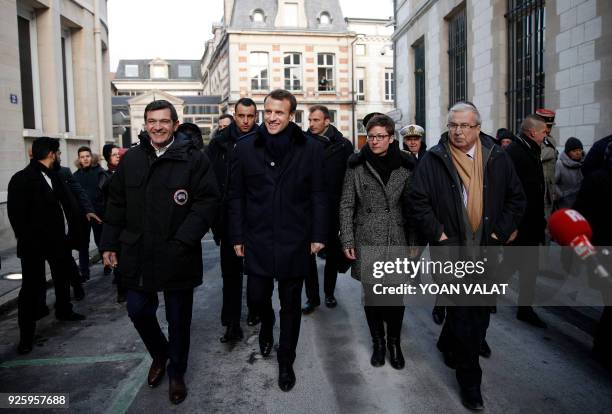 French President Emmanuel Macron walks with Chalons-en-Champagne Mayor Benoist Apparu during a visit to Chalons en Champagne, near Reims on March 1,...