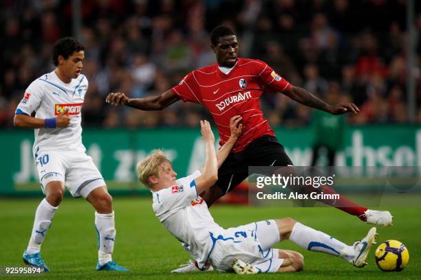 Mohammadou Idrissou of Freiburg is challenged by Andreas Beck and Carlos Eduardo of Hoffenheim during the Bundesliga match between SC Freiburg and...