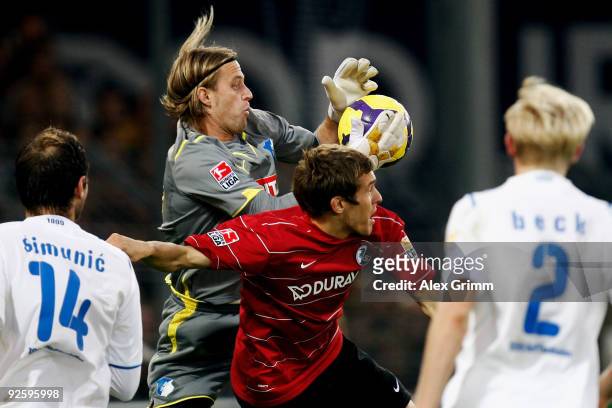 Goalkeeper Timo Hildebrand of Hoffenheim catches the ball ahead of Julian Schuster of Freiburg during the Bundesliga match between SC Freiburg and...