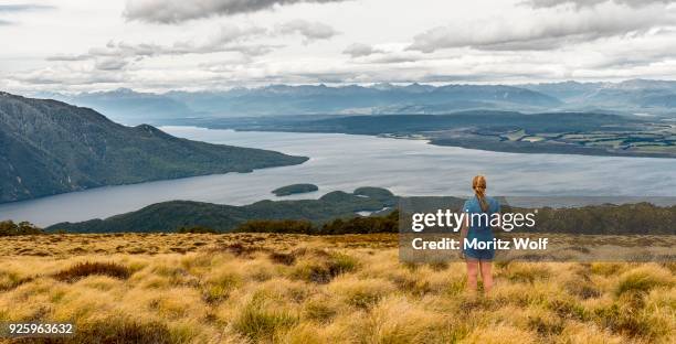 female hiker looking at lake te anau and southfiord, kepler track, fiordland national park, southland, south island, new zealand - te anau stock pictures, royalty-free photos & images