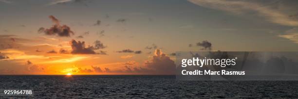 sunset, sun sinking into the sea, cloudy sky, gangehi island, ari atoll, indian ocean, maldives - ari atoll foto e immagini stock
