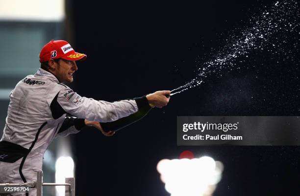 Jenson Button of Great Britain and Brawn GP celebrates on the podium after finishing third during the Abu Dhabi Formula One Grand Prix at the Yas...