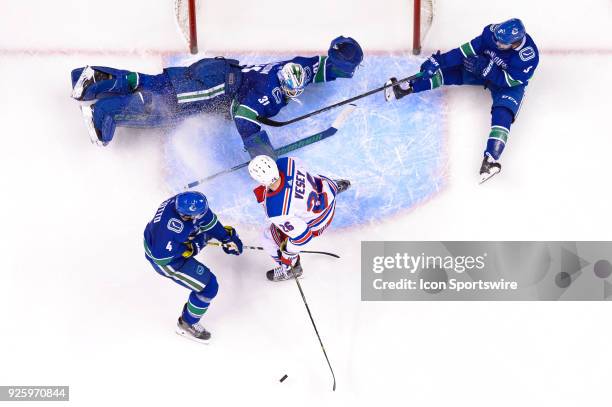 Goalie Anders Nilsson Defenceman Derrick Pouliot and Vancouver Canucks Defenceman Michael Del Zotto defend against New York Rangers Left Wing Jimmy...