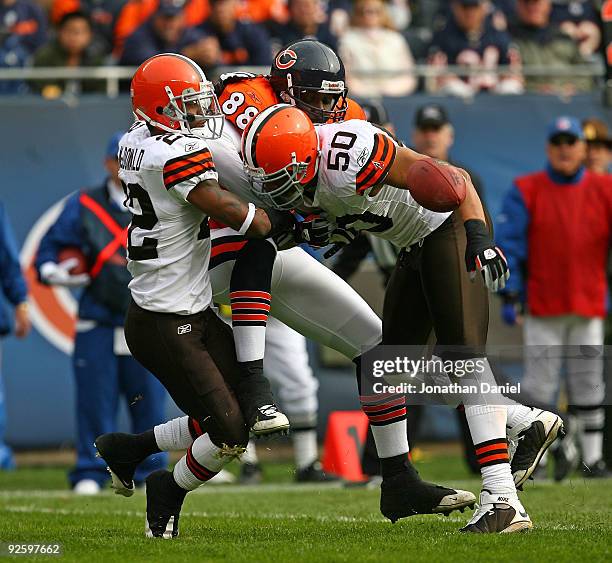 Desmond Clark of the Chicago Bears drops the ball as he is hit by Brandon McDonald and Eric Barton of the Cleveland Browns at Soldier Field on...