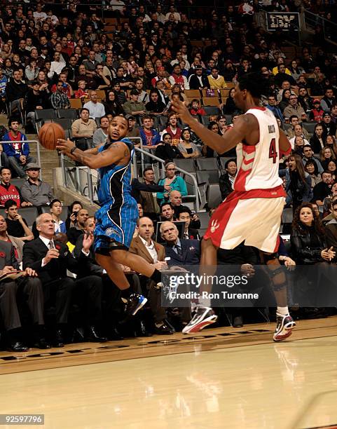 Jameer Nelson of the Orlando Magic gets airborne and tries to save the loose ball and keep it out of the hands of Chris Bosh of the Toronto Raptors...