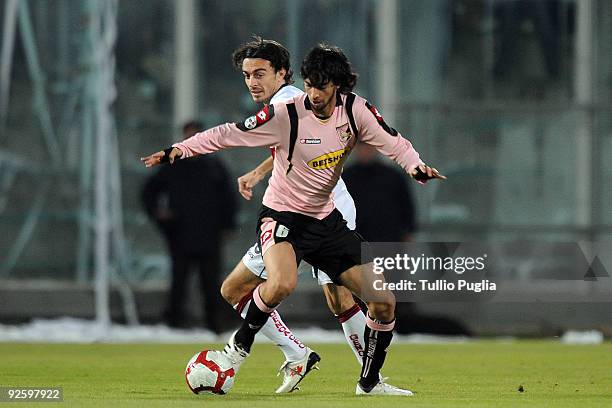 Javier Pastore of Palermo holds off the challenge from Giuseppe Biava of Genoa during the Serie A match between Palermo and Genoa at Stadio Renzo...