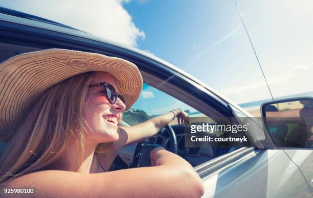 young woman driving a car on the beach. - four wheel drive australia stock pictures, royalty-free photos & images
